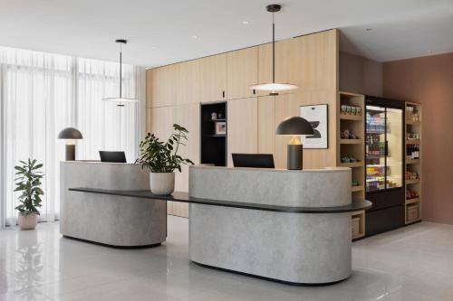 a lobby with two reception desks and potted plants at Residence Inn by Marriott Geneva City Nations in Geneva