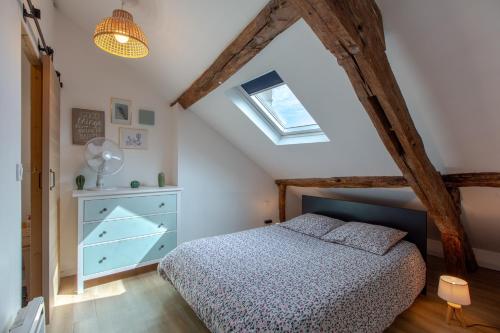 une chambre avec un lit et une lucarne dans l'établissement La Claustra - Entre châteaux et Beauval, à Romorantin-Lanthenay