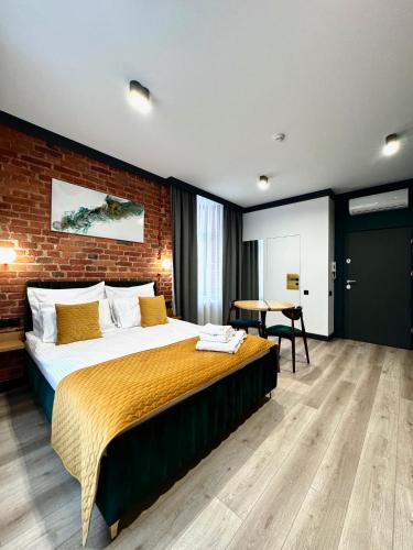 a bedroom with a bed and a brick wall at BIBLIO Apartamenty in Łódź