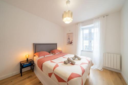 une chambre avec un grand lit avec des oreillers orange dans l'établissement RICHEBOURG à 5min du Jardin des plantes, à Nantes