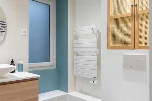 une salle de bain blanche avec un lavabo et une fenêtre dans l'établissement RICHEBOURG à 5min du Jardin des plantes, à Nantes