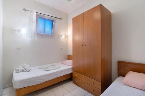 a bedroom with two beds and a wooden cabinet at S6 apartment in Nikiana