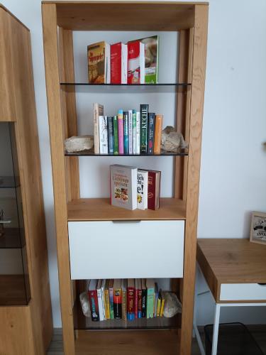 a book shelf filled with books next to a desk at Nationalpark Apartments in Apetlon