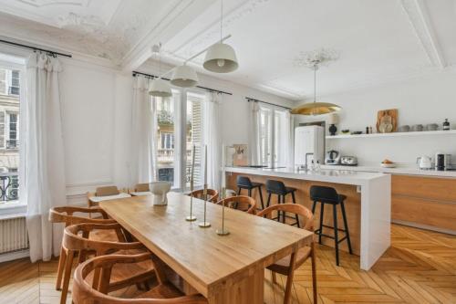 une cuisine et une salle à manger avec une table et des chaises en bois dans l'établissement Appartement Mapio, à Paris