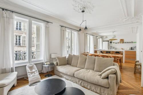 un salon avec un canapé et une table dans l'établissement Appartement Mapio, à Paris