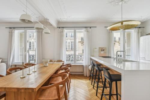 une cuisine avec une grande table et des chaises en bois dans l'établissement Appartement Mapio, à Paris