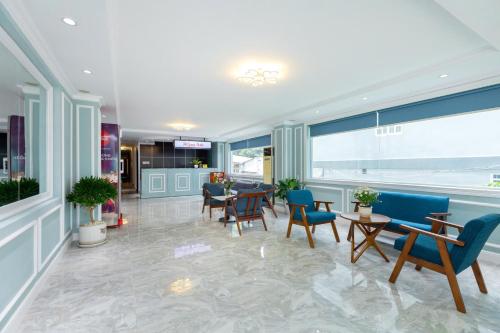 a lobby with chairs and tables in a building at 3H GRAND HOTEL Vũng Tàu in Vung Tau