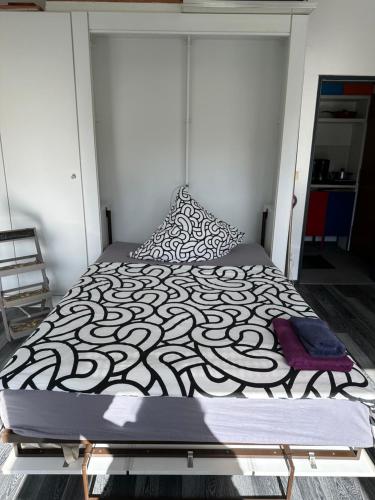 a bed with a black and white comforter and pillows at Kleines Apartment mitten in Bergneustadt in Bergneustadt