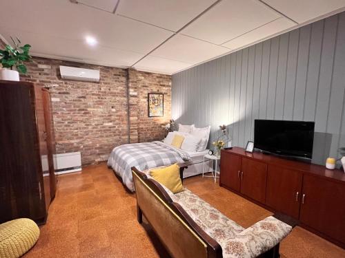 a bedroom with a bed and a tv in a room at The Coachhouse - studio apartment in Goulburn