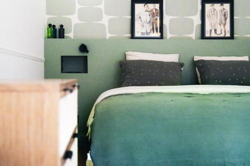 une chambre avec un lit vert avec deux oreillers dans l'établissement Villa Nady, à Pauillac