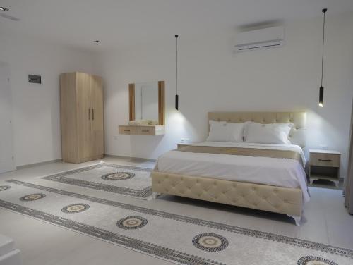 a bedroom with a large bed and a mirror at Shatri Hotel in Vranisht