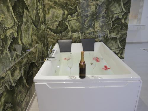 a white sink with a bottle of champagne and wine glasses at Shatri Hotel in Vranisht