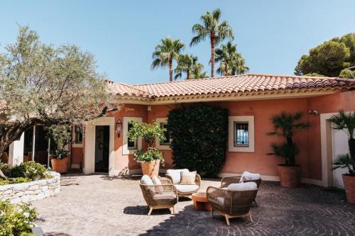 Cette maison dispose d'une terrasse avec des chaises et des palmiers. dans l'établissement Villa Camille, à Fréjus