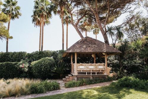 un kiosque dans un jardin planté de palmiers dans l'établissement Villa Camille, à Fréjus