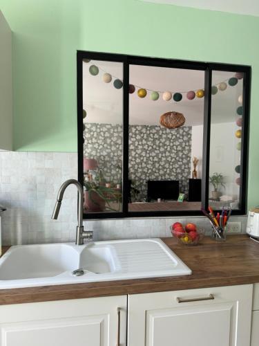 - un comptoir de cuisine avec un évier et un miroir dans l'établissement Appartement proche Marché de Noël, à Strasbourg