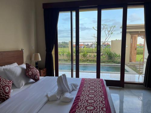 a bedroom with a bed with a view of a pool at Villa Lestari in Ubud
