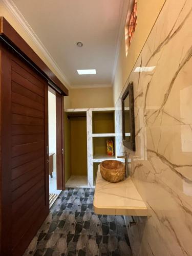 a bathroom with a wooden door and a sink at Villa Lestari in Ubud