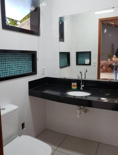 a bathroom with a black sink and a toilet at Casa atrás do Horto florestal in Santa Maria Madalena