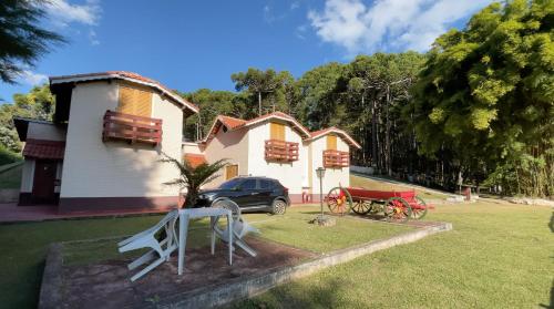 a house with a car parked in front of it at Pousada Domos Serra do Sol in Monte Verde