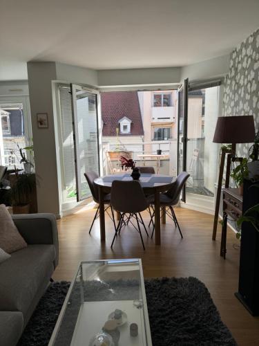un salon avec une table, des chaises et un canapé dans l'établissement Appartement proche Marché de Noël, à Strasbourg