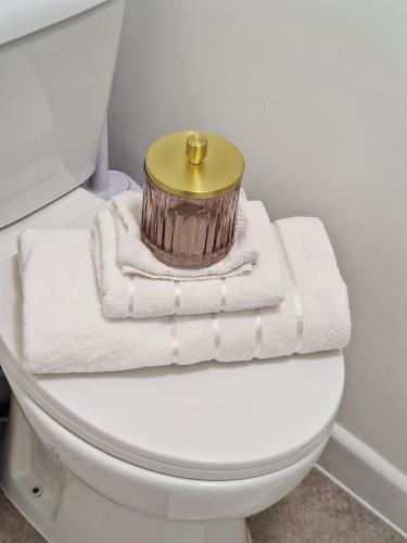 a white toilet with a gold container on top of it at 12 B Market Street in Watford