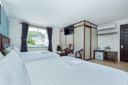 a hotel room with two beds and a window at 3H GRAND HOTEL Vũng Tàu in Vung Tau