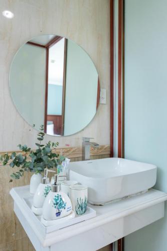 a bathroom with a white sink and a mirror at 3H GRAND HOTEL Vũng Tàu in Vung Tau