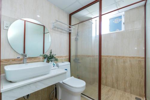 a bathroom with a white toilet and a mirror at 3H GRAND HOTEL Vũng Tàu in Vung Tau