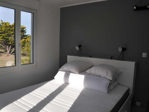 - un lit blanc dans une chambre avec fenêtre dans l'établissement Maison de Famille sur la Côte Sauvage - FR-1-418-204, à Bangor