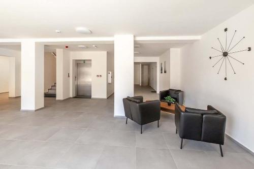 a lobby with chairs and a clock on the wall at Apartmán Na peci Deštné in Deštné v Orlických horách