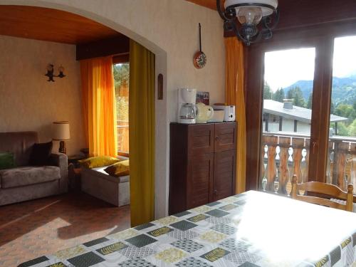 - un salon avec vue sur un balcon dans l'établissement Location 2P aux Gets, 5 pers., accès pistes, garage, à 300m des commerces - FR-1-802-56, aux Gets