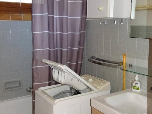 une salle de bain avec une machine à laver et un lavabo dans l'établissement Location 2P aux Gets, 5 pers., accès pistes, garage, à 300m des commerces - FR-1-802-56, aux Gets