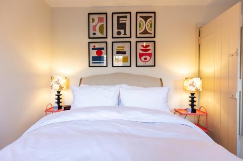 a bedroom with a white bed with two lamps at Stable Flat on Gorgeous Rural Farm in Goadby Marwood