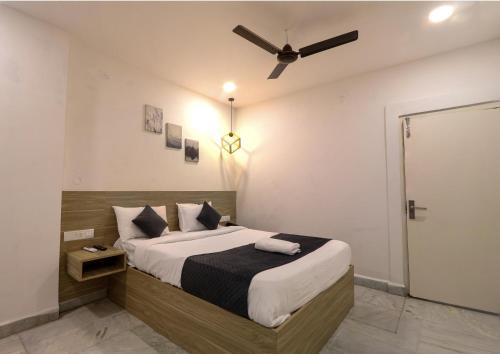 a bedroom with a bed with a ceiling fan at Frenotel in Hyderabad