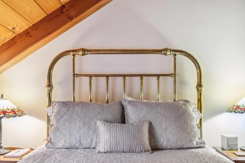 a bed with a metal headboard in a bedroom at Tigertown Lodge home in White River Junction