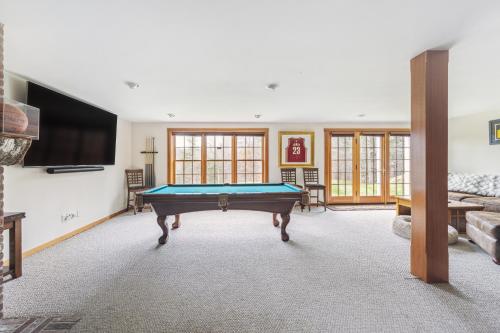 a living room with a pool table and a tv at Tigertown Lodge home in White River Junction