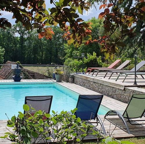 two chairs and a swimming pool with a deck at Le Roulottes du Petit Gouffre de Padirac avec Spa in Padirac
