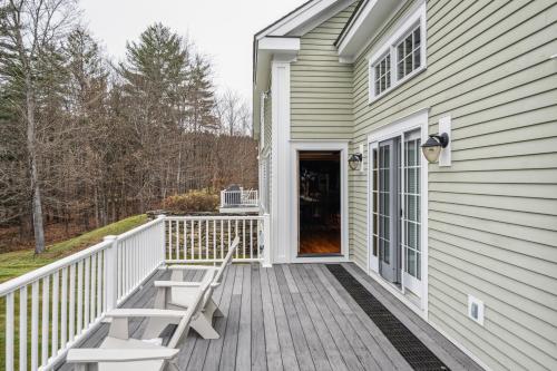 a porch of a house with two chairs on it at Tigertown Lodge home in White River Junction