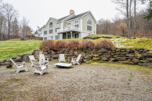 a house with a bunch of chairs in front of it at Tigertown Lodge home in White River Junction