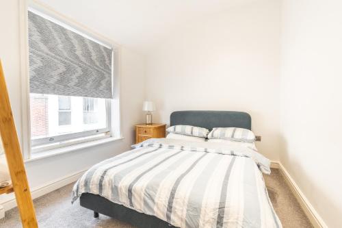 ブライトン＆ホーブにあるCharming & Chic, Cosy Beach Nest, Just 2-min walk!のベッドと窓のある寝室
