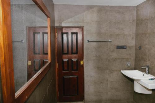 une salle de bain avec un lavabo et un miroir dans l'établissement Solace Villa, à Dikwella