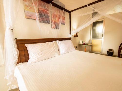 Кровать или кровати в номере Frangipani Beach Villa