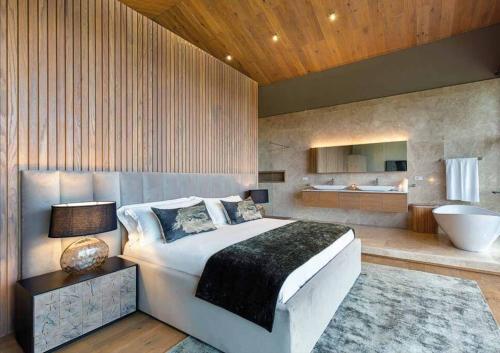 Un dormitorio con una cama grande y un baño. en Villa One by IHR, en Rivière Noire