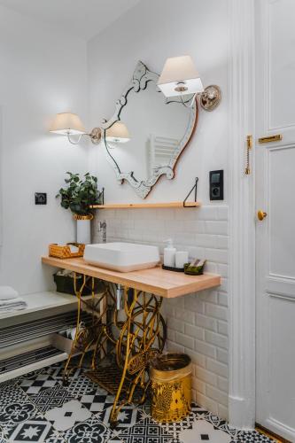 une salle de bain avec un lavabo et un miroir au mur dans l'établissement RoomChic - Les Ambassadeurs, à Vichy