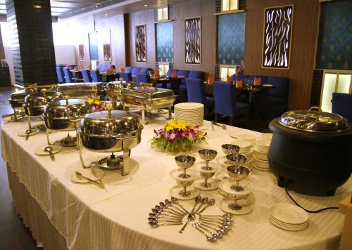 a table with plates and utensils on it in a restaurant at Hotel Sonar Tori in Agartala