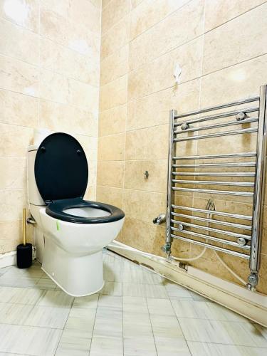 a bathroom with a toilet with a black seat at Best Places to Stay in Kent in Kent