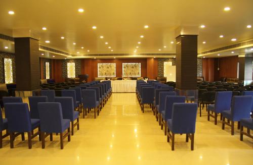 a banquet hall with blue chairs and a table at Hotel Sonar Tori in Agartala