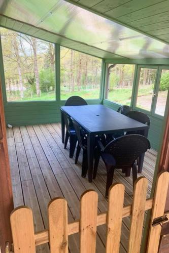 une terrasse couverte avec une table et des chaises. dans l'établissement HAUTE VIENNE 87 Location Gîte au Lac de Vassivière Maison de Vacances Familiale et Pêche à Peyrat le Château, à Peyrat-le-Château