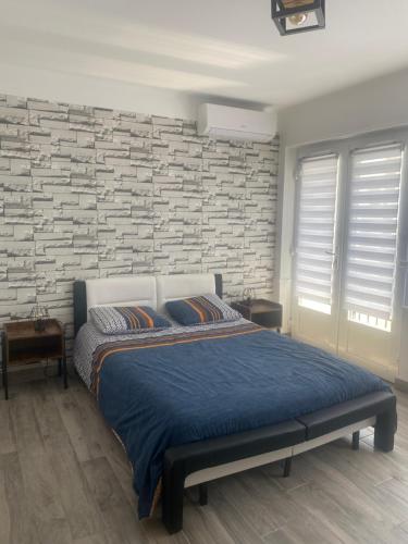 une chambre avec un lit et un mur de briques dans l'établissement Grand T2 tout équipé centre-ville, spacieux et lumineux, 1 chambre, 1 à 4 pers, possible 5 pers avec lit d'appoint pour 15 euros, climatisation, wifi, balcons, parking privé surveillé compris, à Lorient