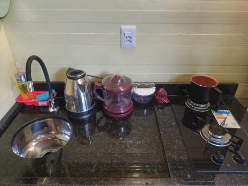 a kitchen counter with a sink and a stove at Casa na Vila de Abraão in Abraão